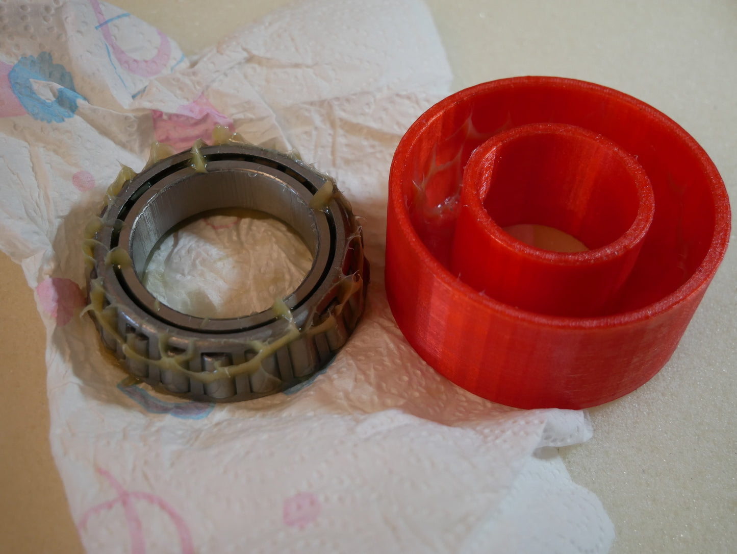 Grease packing tool for Land Rover Defender wheel bearings — This tool helps you push grease quick and clean into the wheel bearings of the Land Rover Defender in the rear. You put the bearing like shown in to the cup. Than you put some grease in it, put the pusher in the correct orientation (as you can also see in the pictures) in it and push. Take the bearing out (some slaps on the back required) and check if it has enough grease.