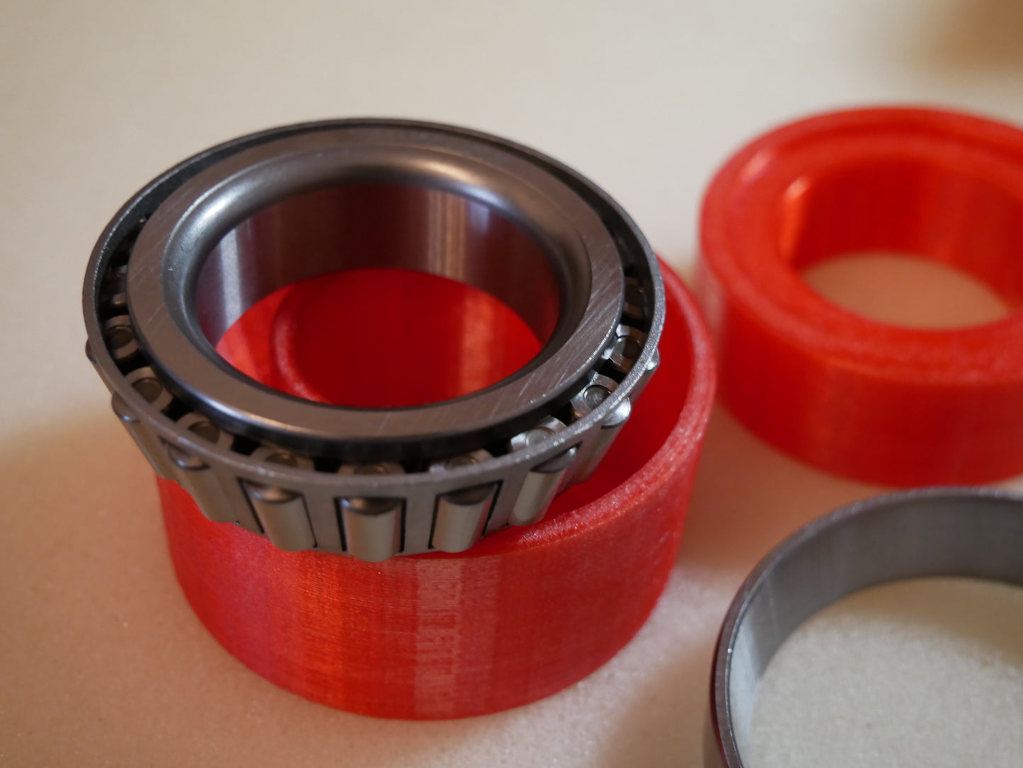 Grease packing tool for Land Rover Defender wheel bearings — This tool helps you push grease quick and clean into the wheel bearings of the Land Rover Defender in the rear. You put the bearing like shown in to the cup. Than you put some grease in it, put the pusher in the correct orientation (as you can also see in the pictures) in it and push. Take the bearing out (some slaps on the back required) and check if it has enough grease.
